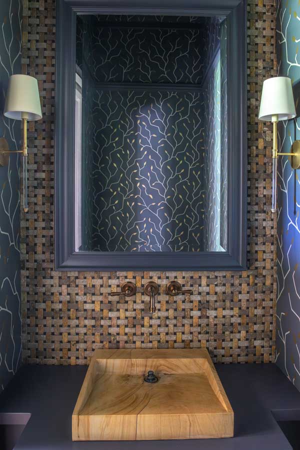 Camera facing a door at the end of hallway with blue walls and wooden floor